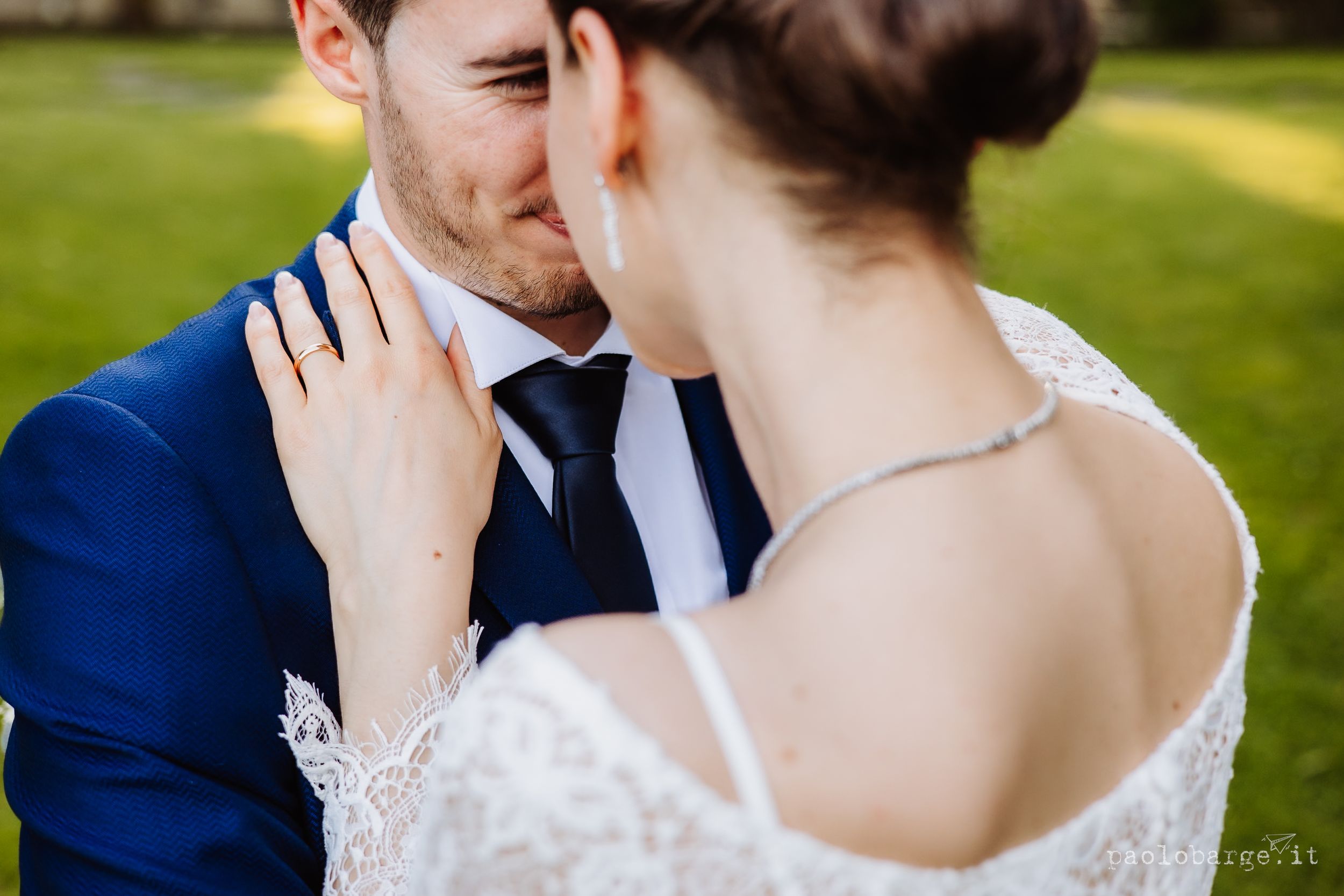 Close up shot of romantic bride and groom sharing an intimate moment in a sunny garden setting.