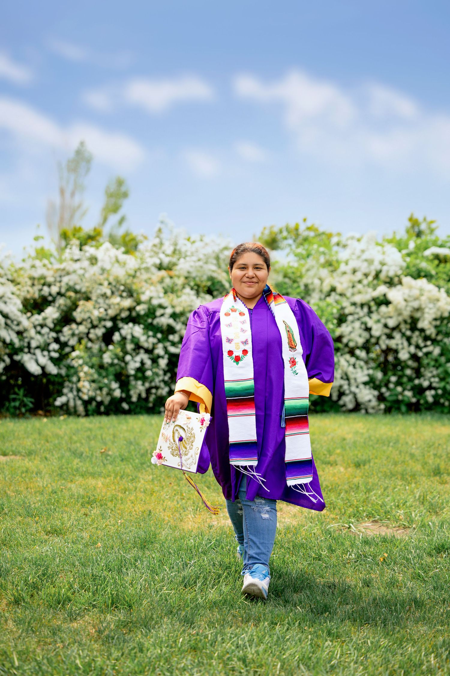Candid shot of Alejandra laughing during her cap and gown mini session at Van Buren Street Beach Access in Van Buren County.