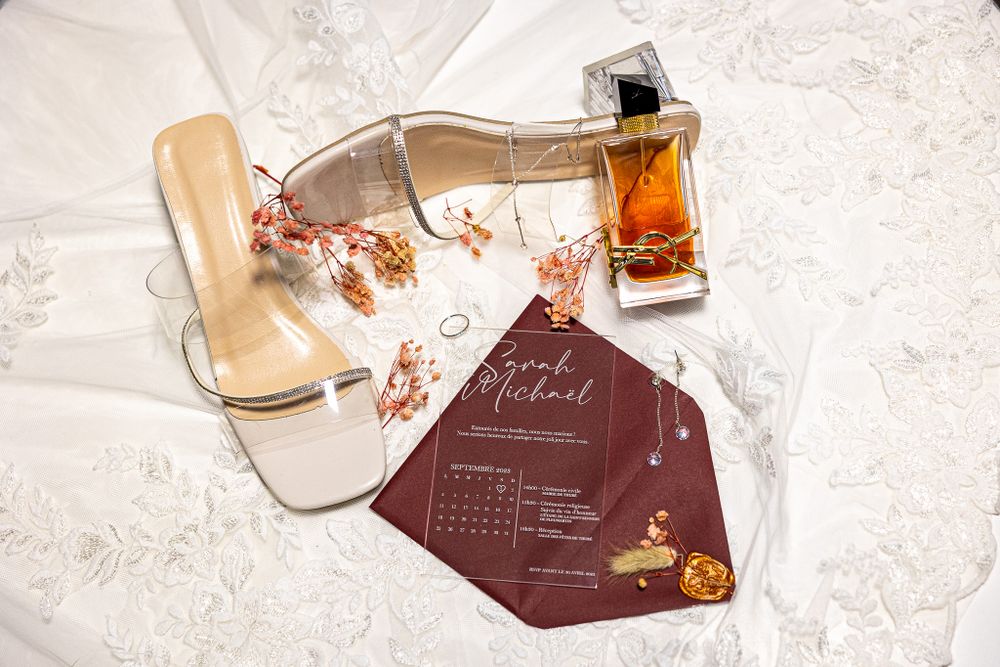 Wedding details including elegant burgundy invitation cards and decor elements arranged artistically.
