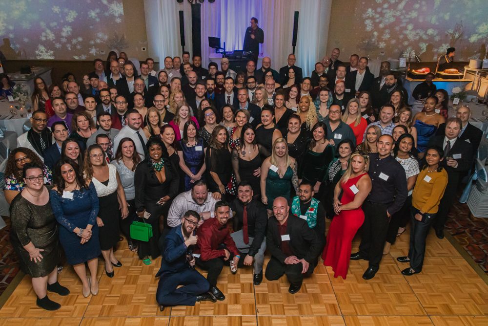 Large group portrait of graduates and guests at formal celebration.
