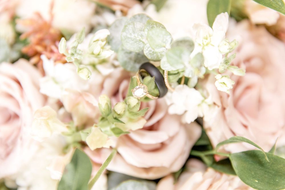 Soft pink and white roses with delicate greenery in romantic wedding bouquet arrangement.