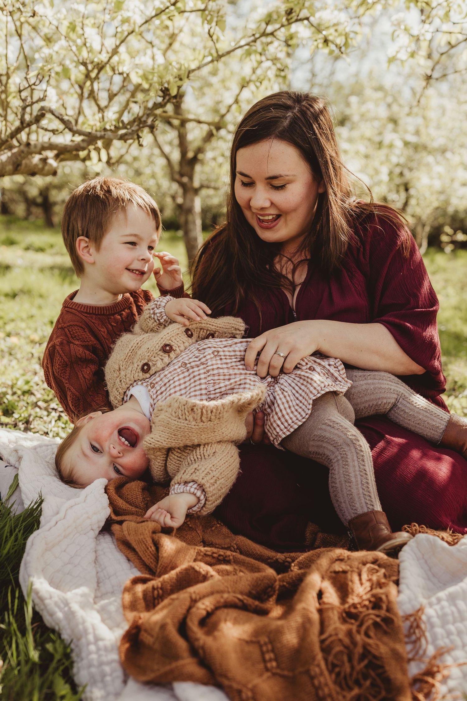 Cozy family moment with stuffed bunny on blanket during spring blossom season outdoors.
