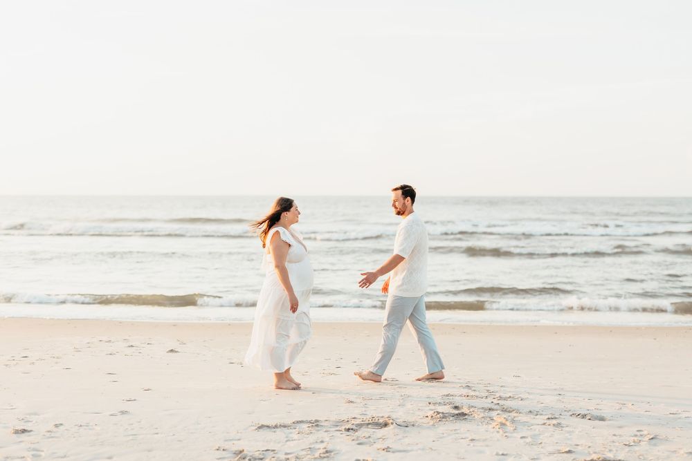 Couple walking together on a pristine white sandy beach. Sunrise Wrightsville beach wilmington nc