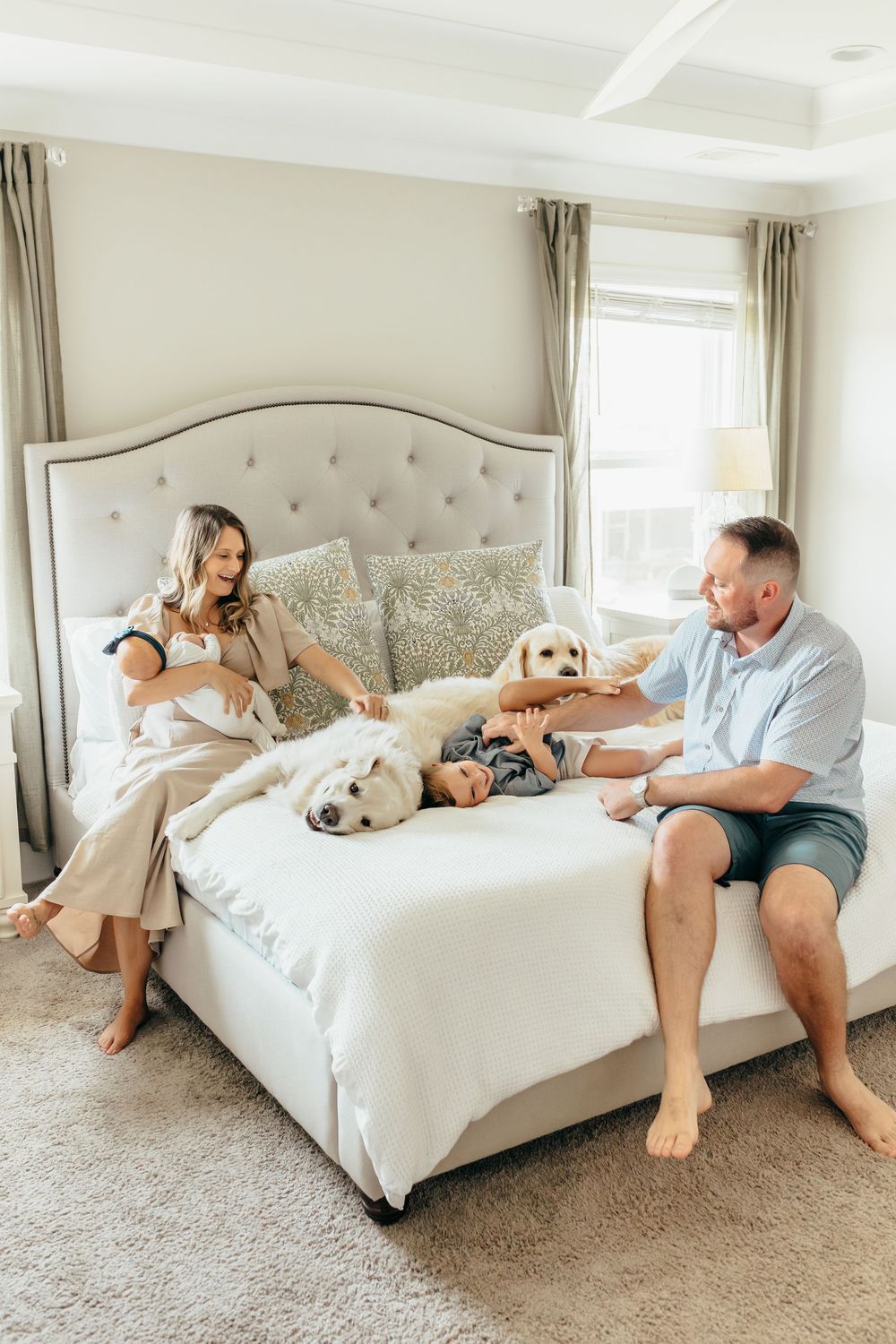 Multiple heartwarming photos show a couple lounging on a plush white bed with their dogs enjoying a relaxing moment together.