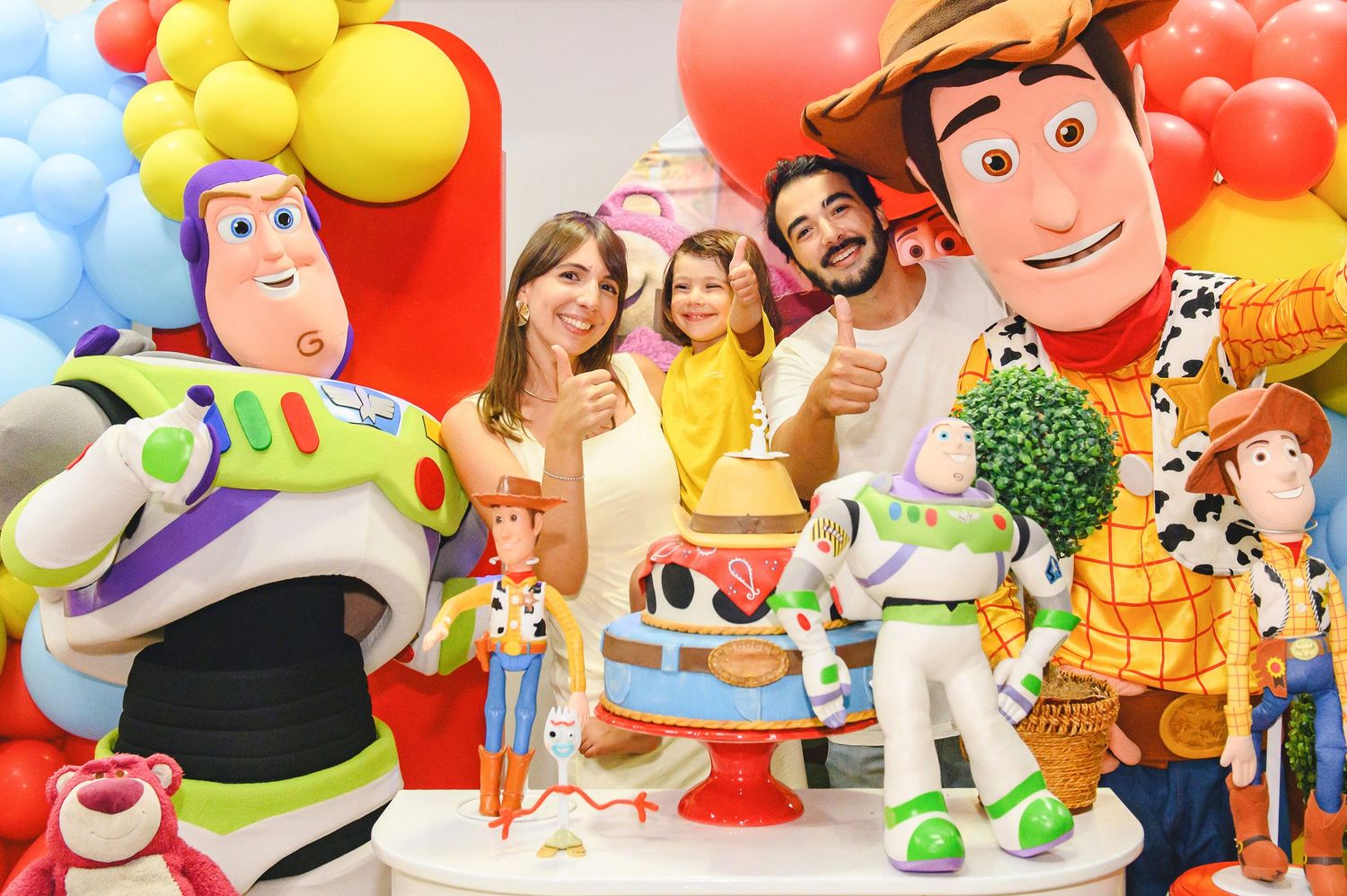 Colorful birthday party setup featuring Toy Story characters Buzz Lightyear and Woody with balloons in the background.
