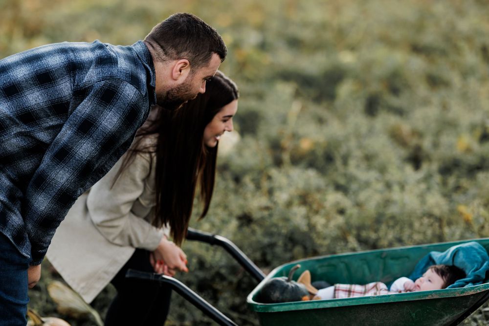 A couple leaning over to look at something in a stroller outdoors.