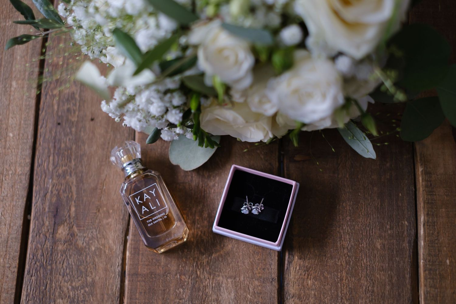 Bride day time perfume, new earrings and bouquet.