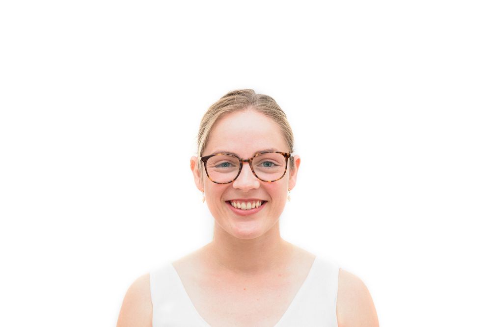 Portrait of person in white top and glasses against white background.
