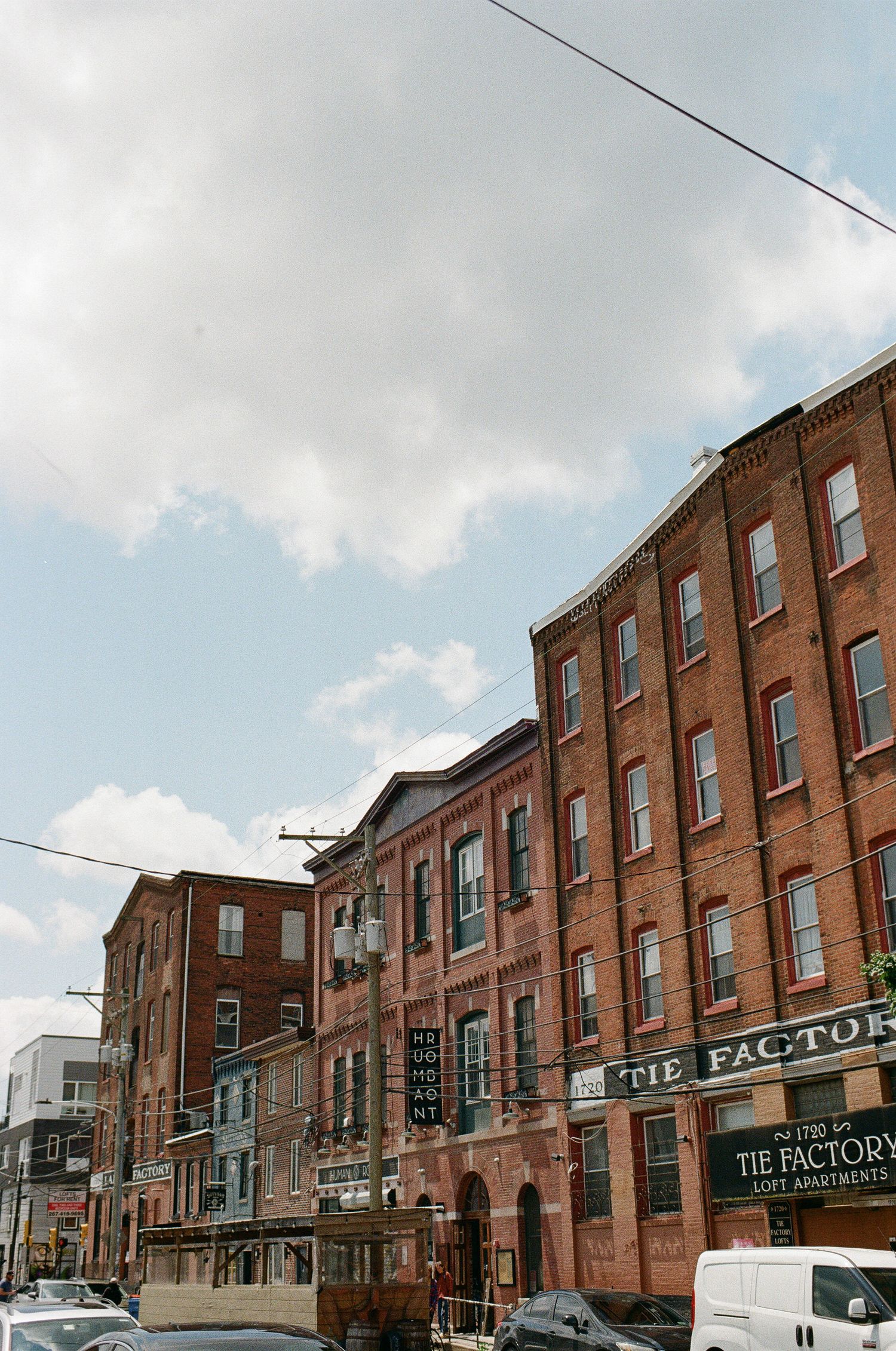 Historical brick buildings with industrial architecture line a street in a revitalized downtown Factory District area.
