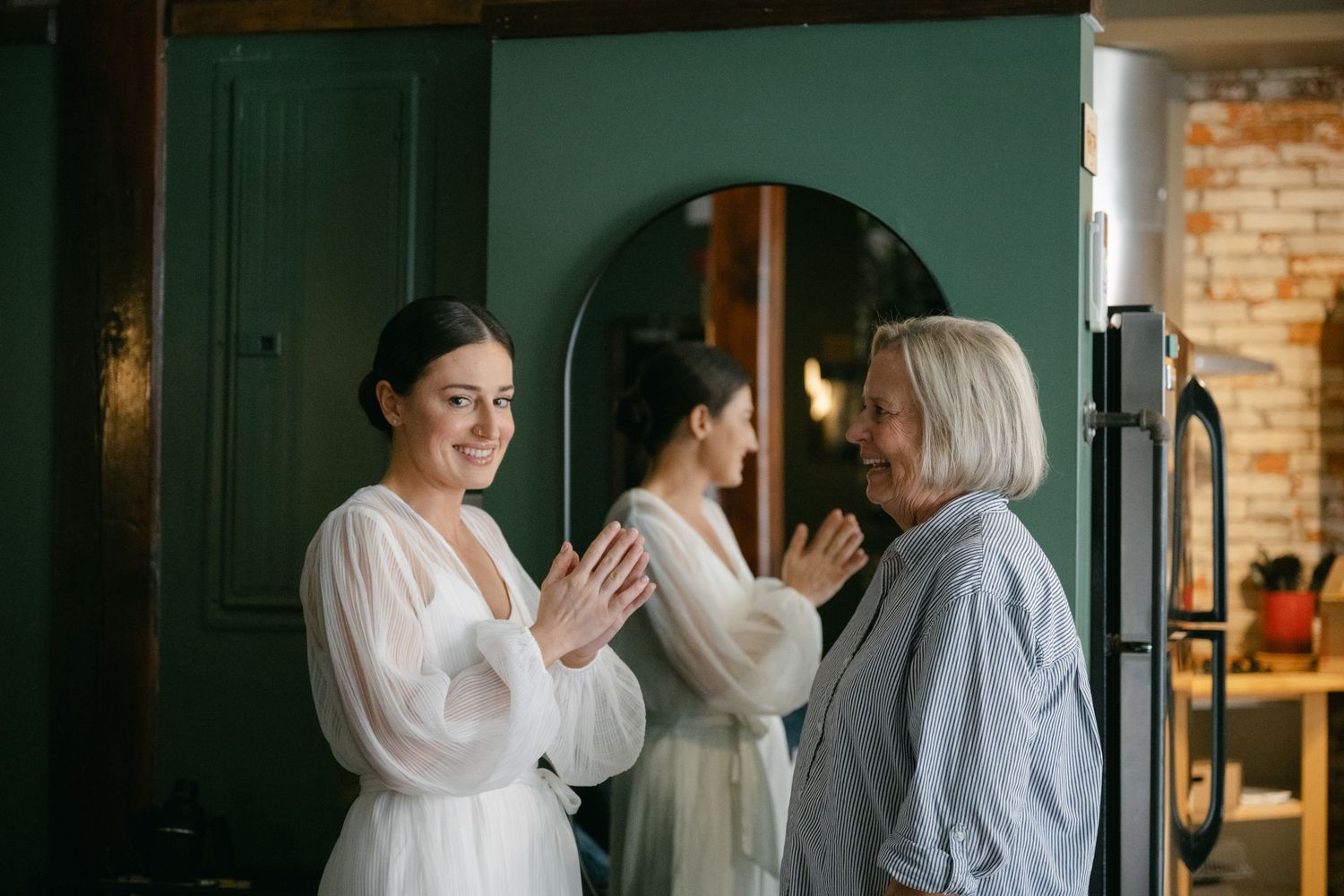 A sequence of wedding preparation moments captured in soft lighting against dark teal walls and exposed brick.