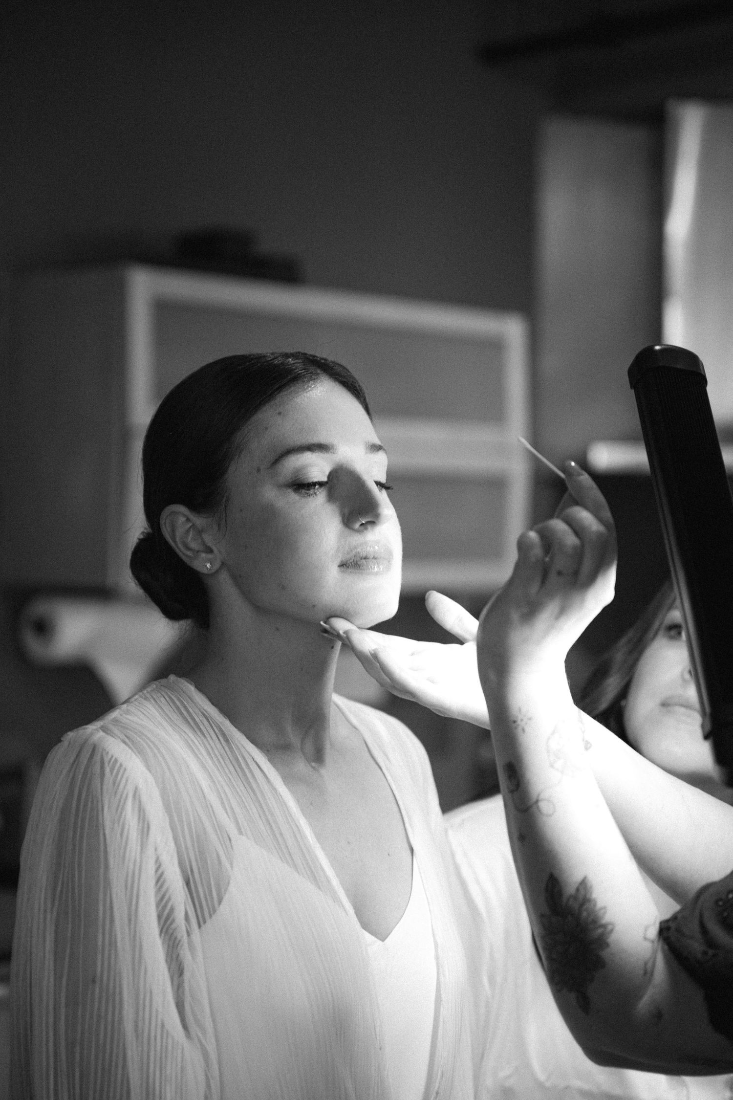A sequence of black and white photos showing lipstick being applied in dramatic lighting.