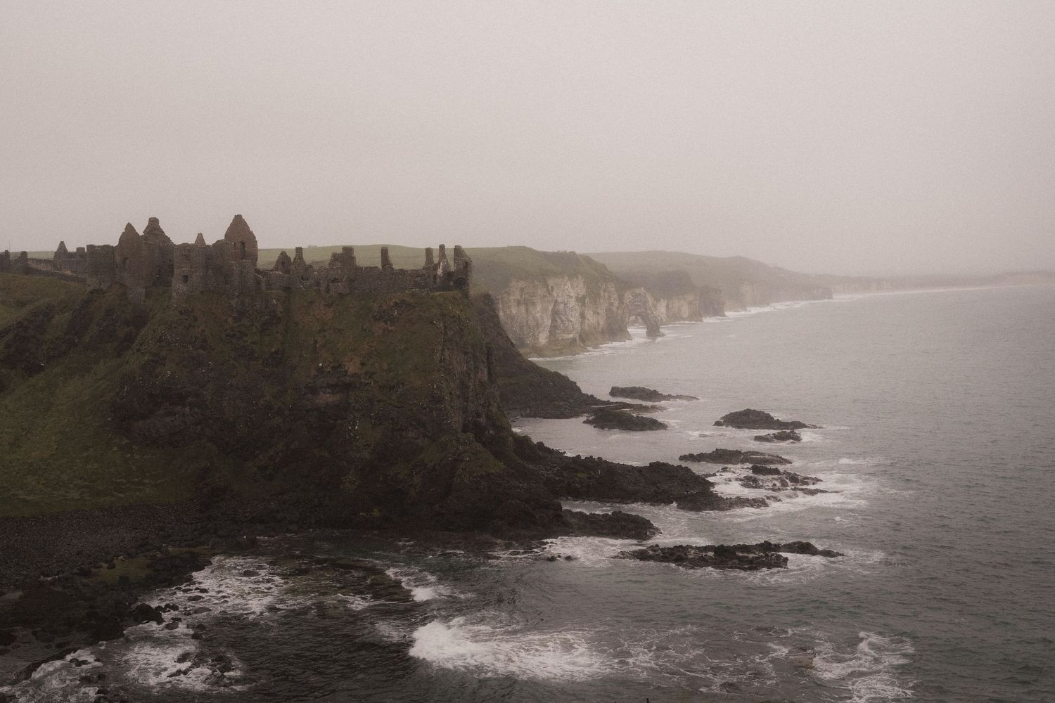 Dramatic rocky coastline in Northern Ireland in misty weather during Elopement.