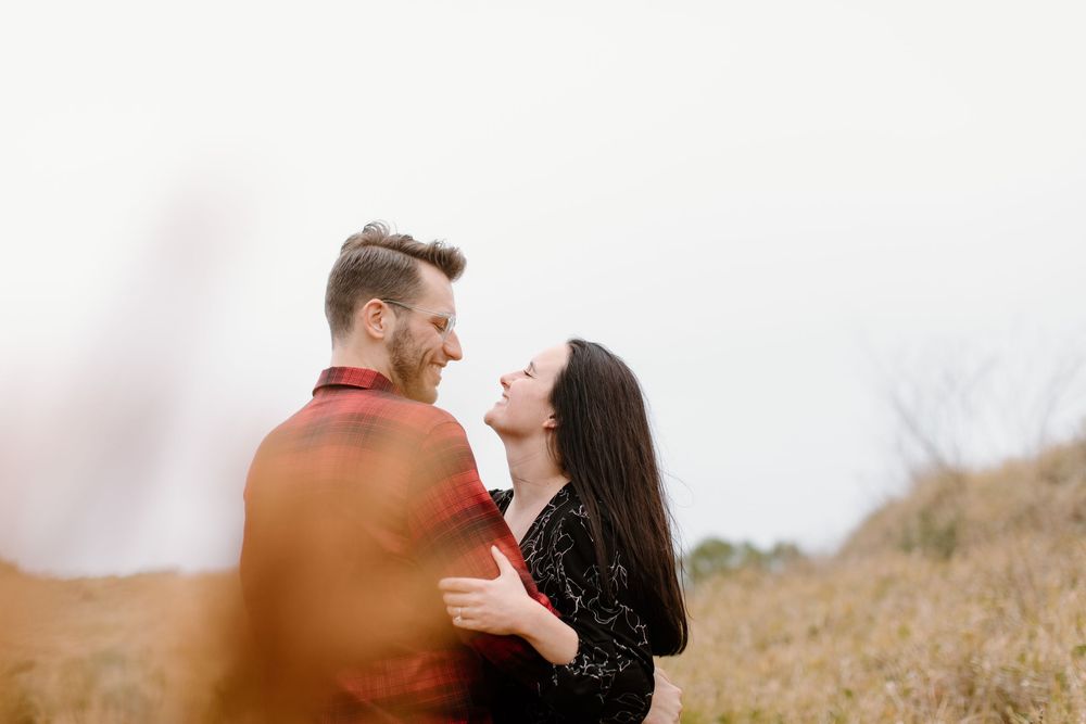 Romantic couple sharing a tender moment in a sunny field.