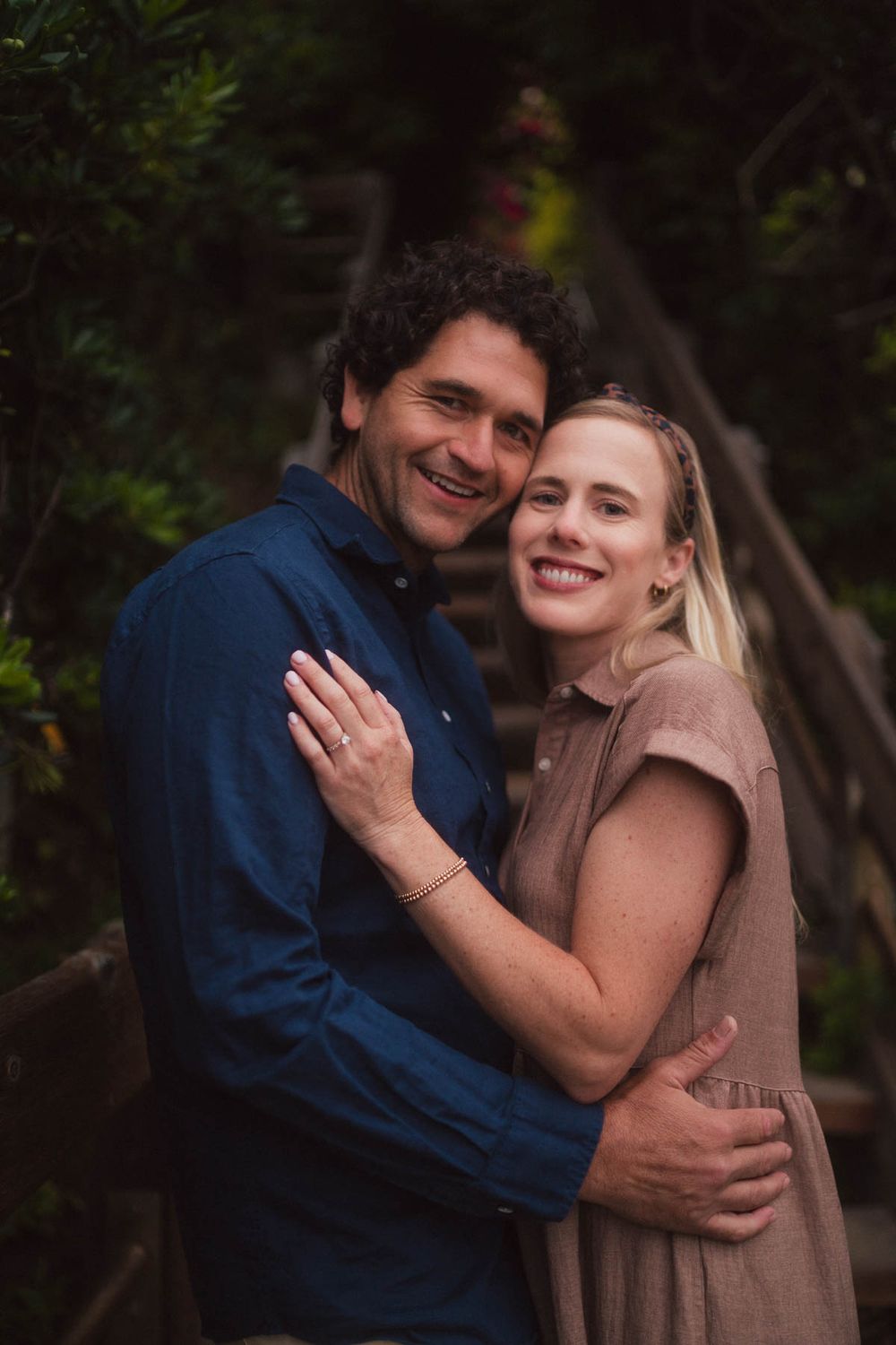 A loving couple shares tender hugs and joyful moments in a series of candid outdoor portrait photos.
