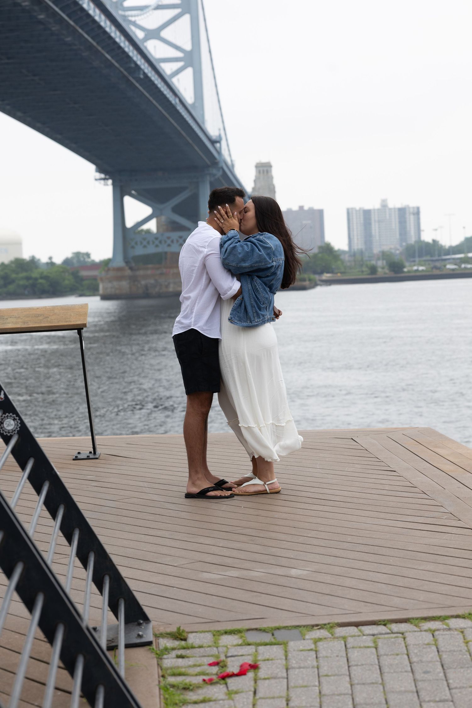 A series of photos showing someone resting on a wooden deck by a bridge over water on a cloudy day.