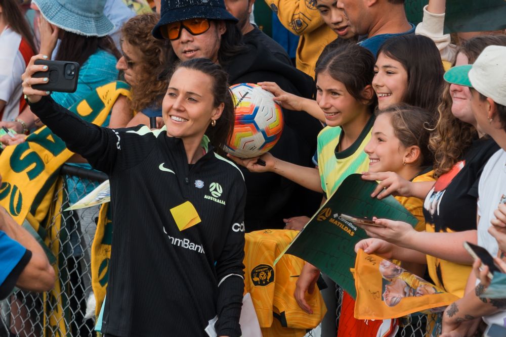 Caitlin Foord takes photos with fans at a Matildas match. © SIX84 Photography, Event Photography