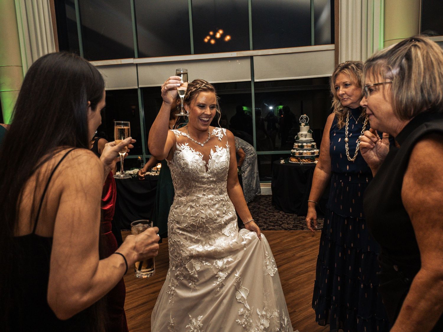 Evening wedding reception with guests celebrating in an elegantly lit indoor venue.