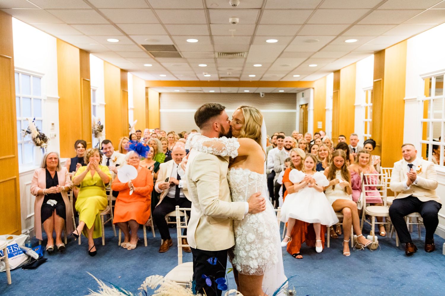 Dance party in a bright indoor venue with people celebrating on a carpeted floor.
