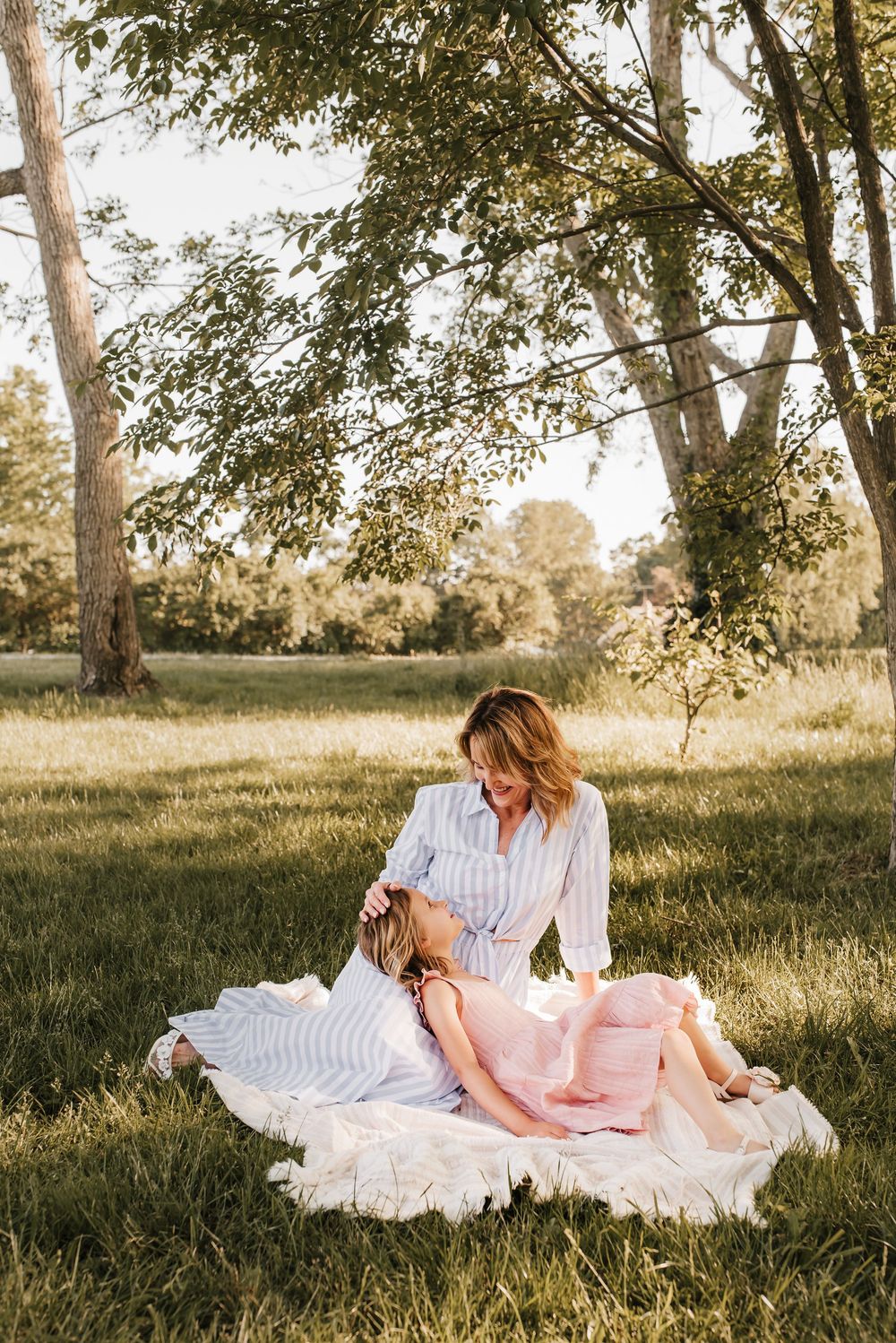 mom and daughter lay together and enjoy the summer air