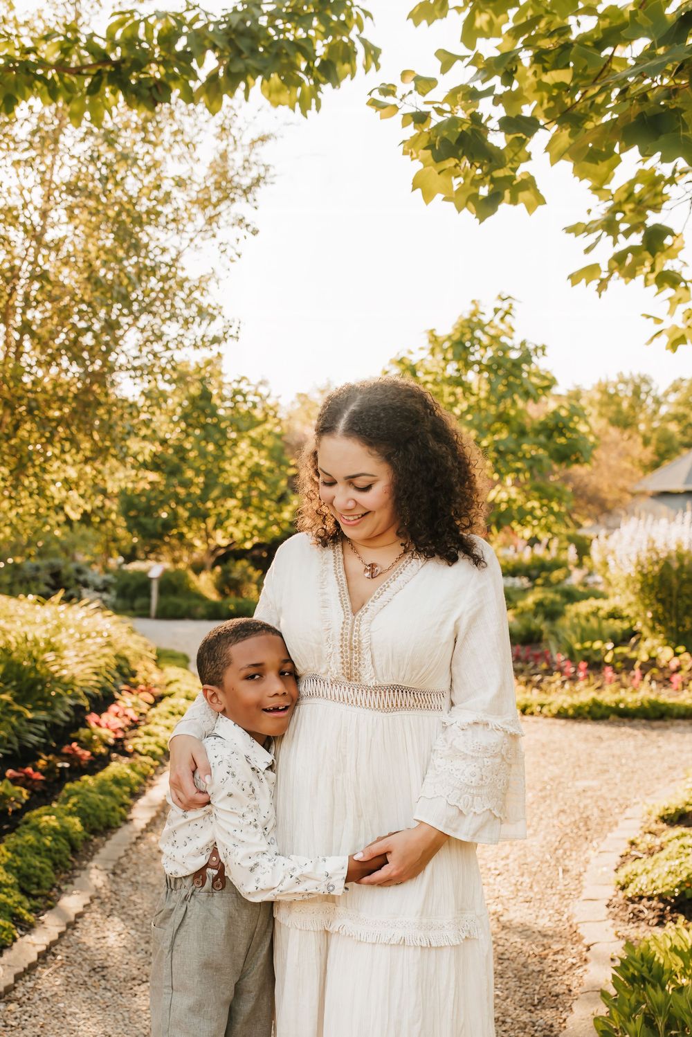 son hugs mom in beautiful floral garden