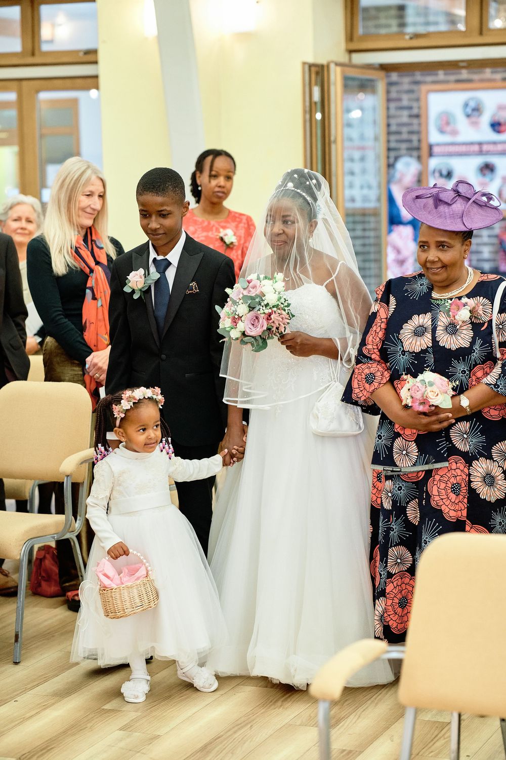 A wedding ceremony takes place in a venue with attendees gathered to celebrate the special occasion.