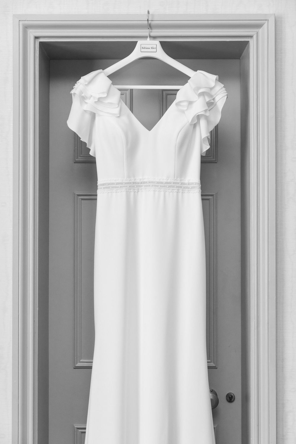 Louisa’s elegant wedding dress hanging on a door at Audley’s Wood Hotel before the bridal preparations began.