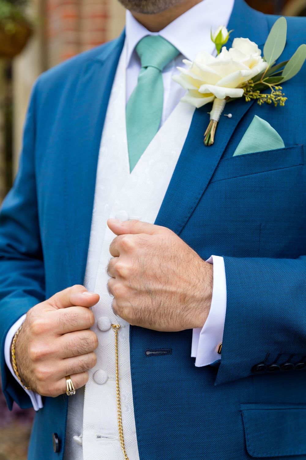 Close-up of Alan’s blue suit and white rose buttonhole before the wedding ceremony at Audley’s Wood Hotel.