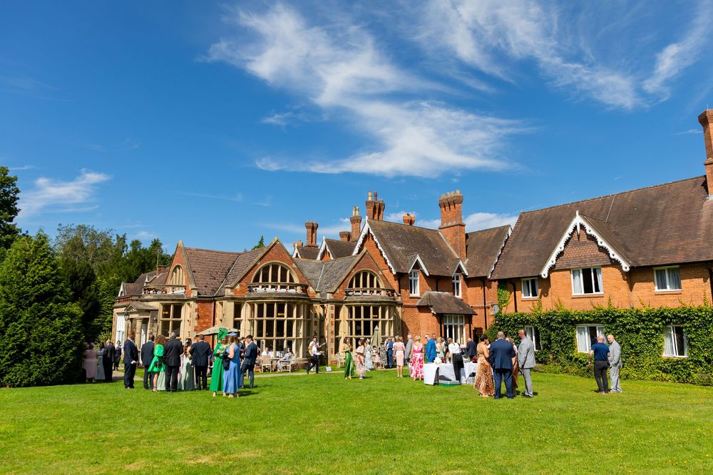 Guests enjoying the sunny drinks reception on the lawn at Audley’s Wood Hotel.