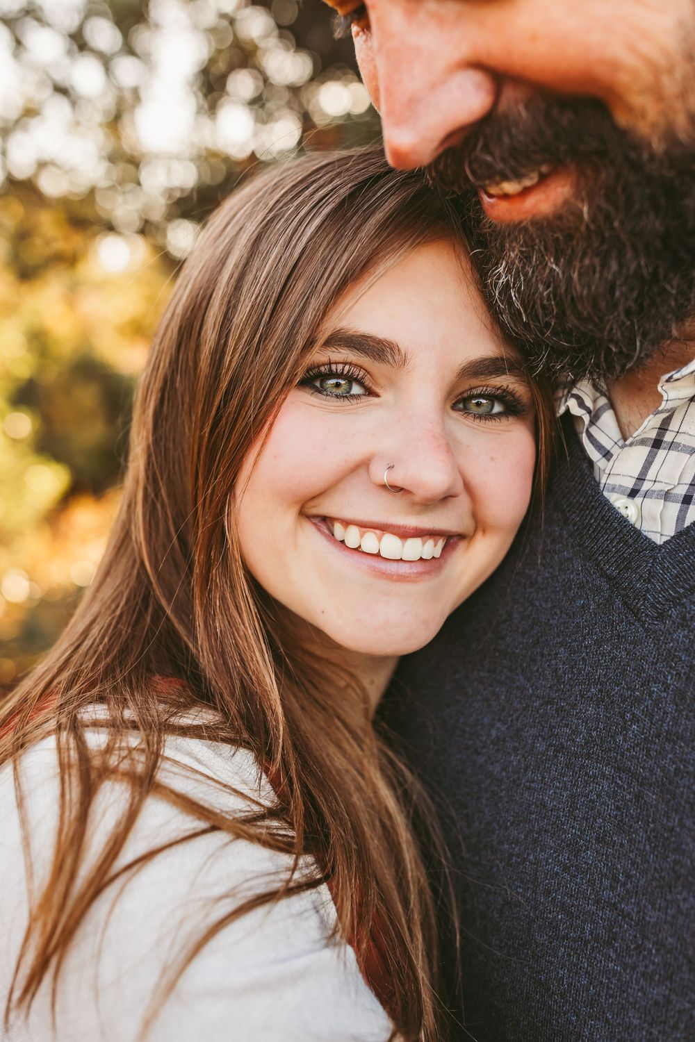Close up candid portrait of couple embracing during golden hour outdoor photoshoot.
