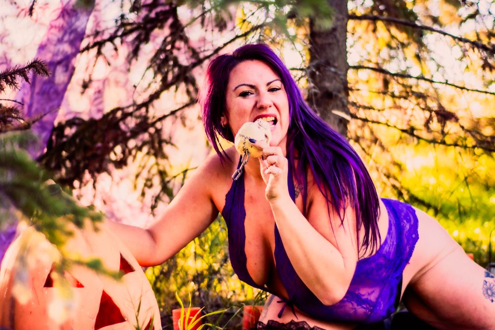 Halloween-themed forest scene in purple and gold lighting with festive decorations.