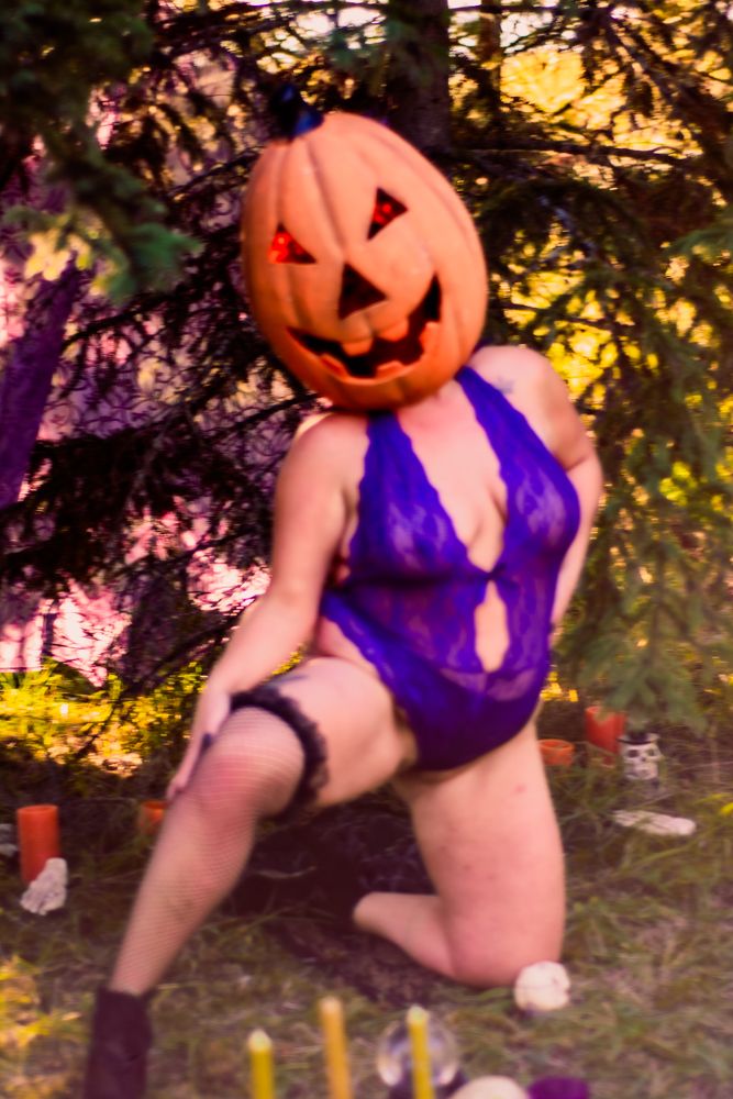 Halloween themed composition with glowing jack-o-lantern and purple accents in forest setting.