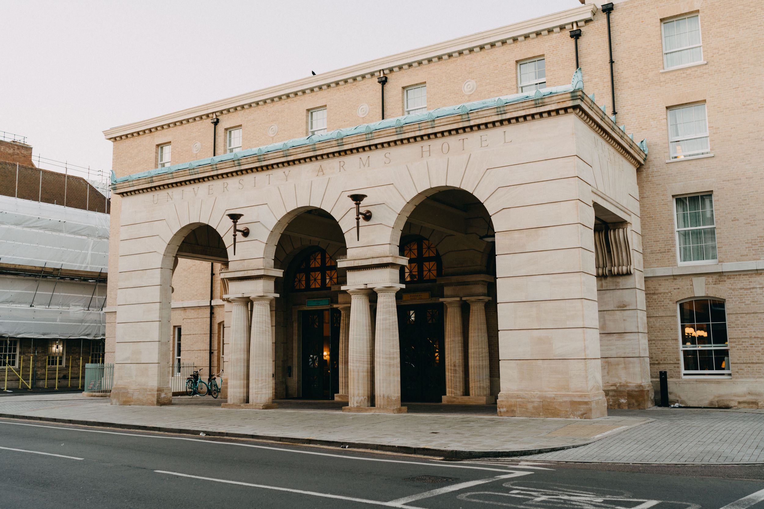 University Arms Hotel - An elegant beige stone building entrance with classic arched columns and architectural details.