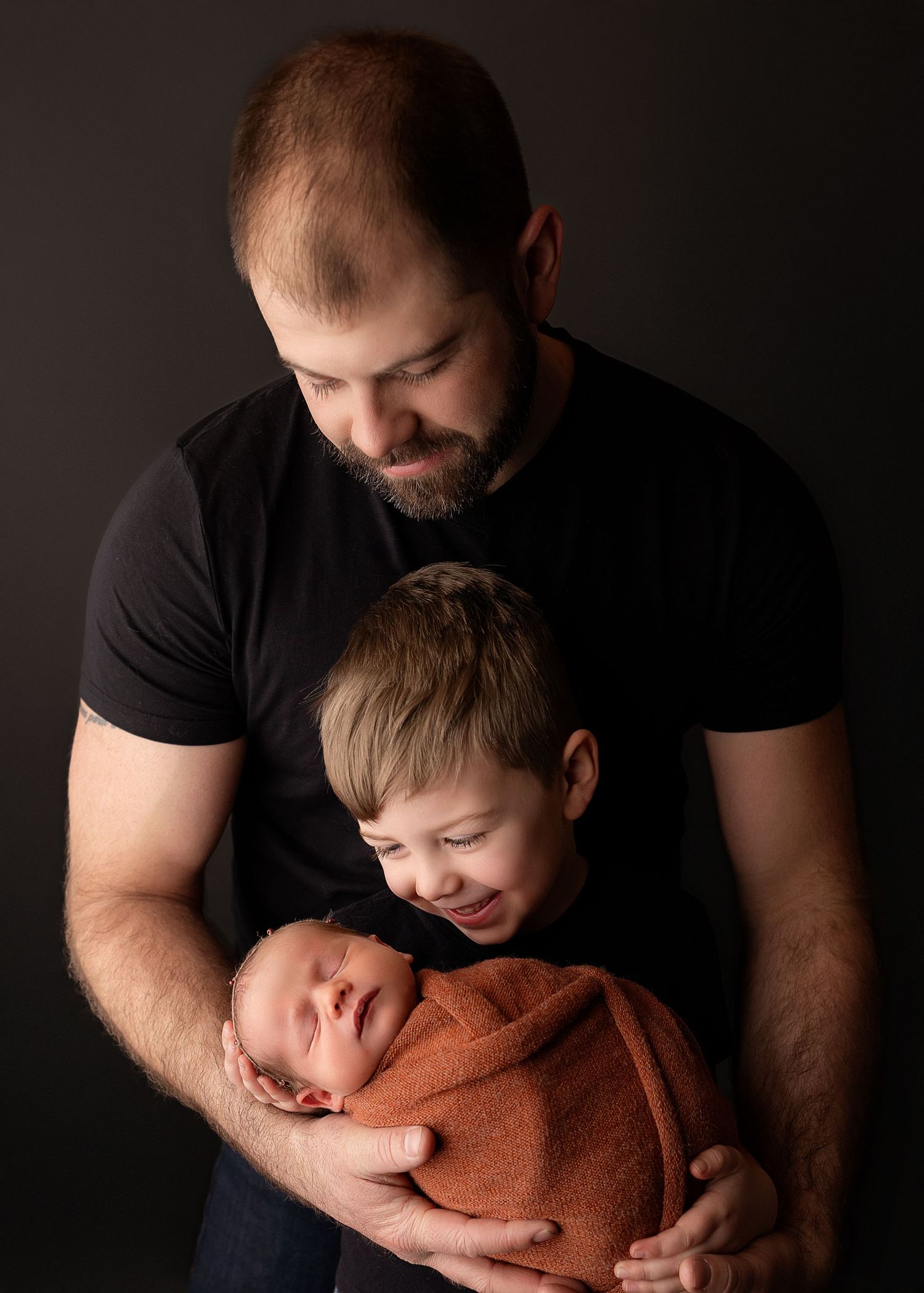 Professional photo of a newborn baby with brother and dad