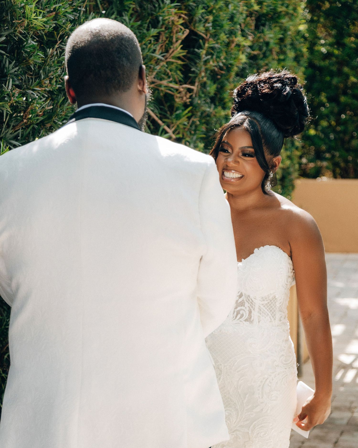 A romantic wedding moment captured outdoors with the couple in white formal attire.