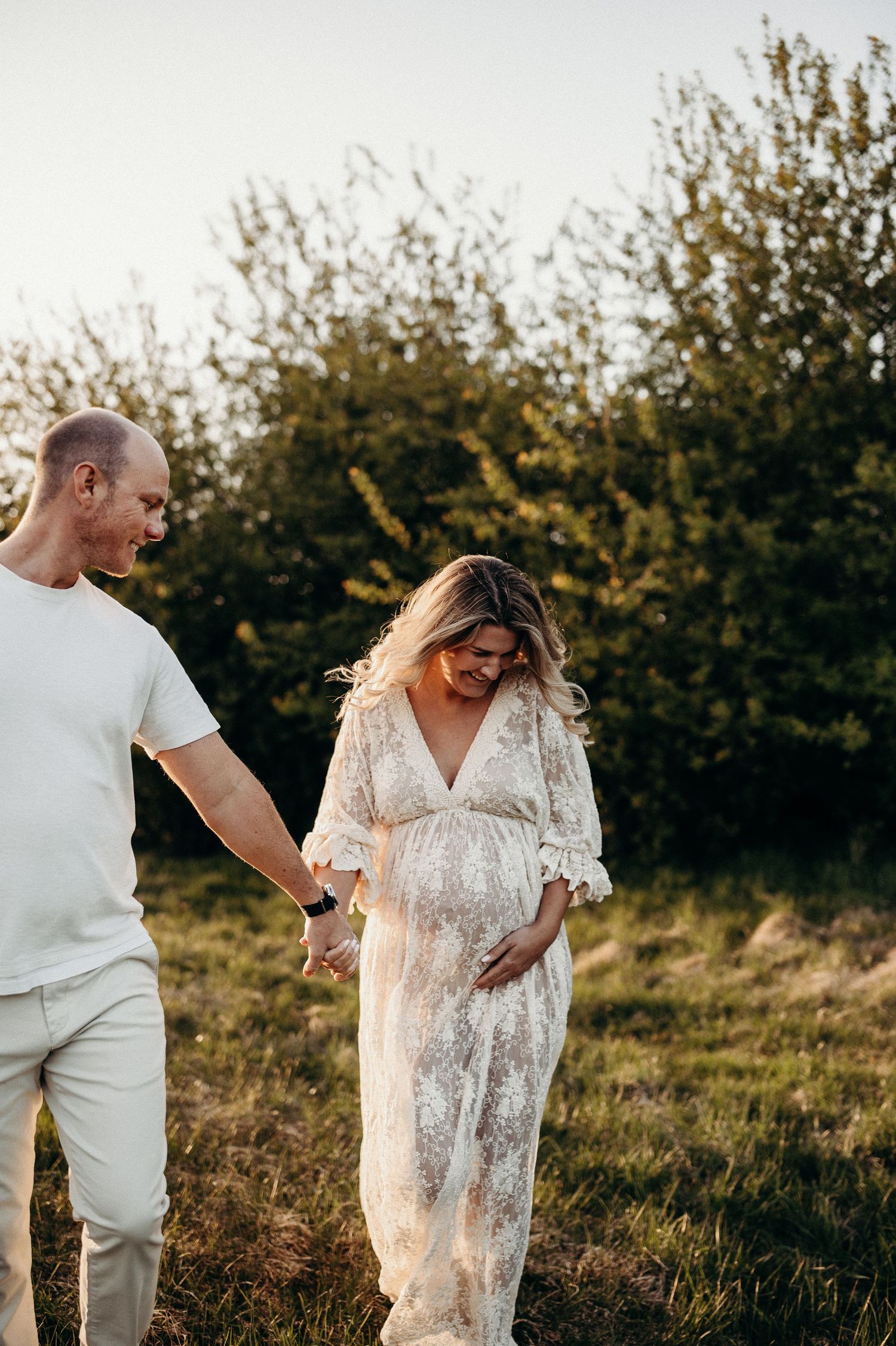 gravid kvinna i vit spetsklänning med v-ringning och slits
