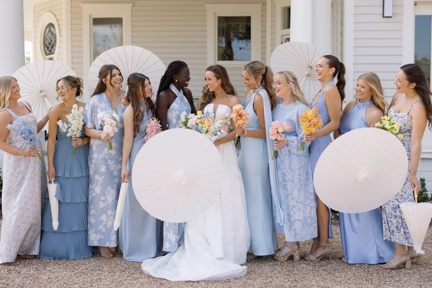 Groups of people in coordinated light blue bridesmaid dresses pose and interact at a wedding event.