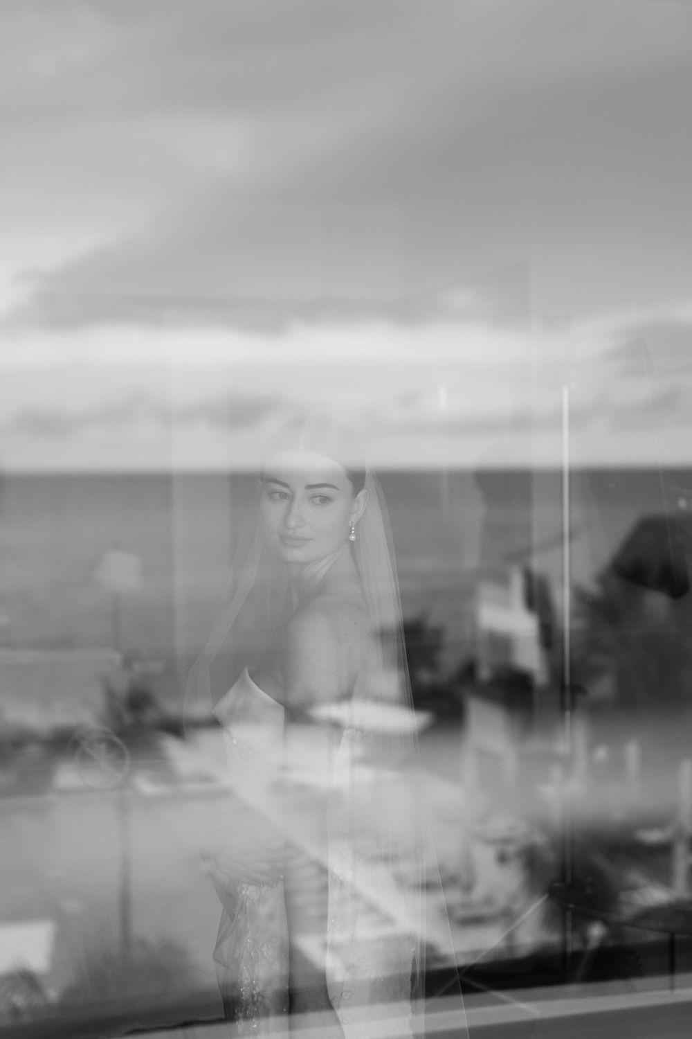 A misty greyscale landscape panorama with blurred architectural silhouettes against a cloudy sky.