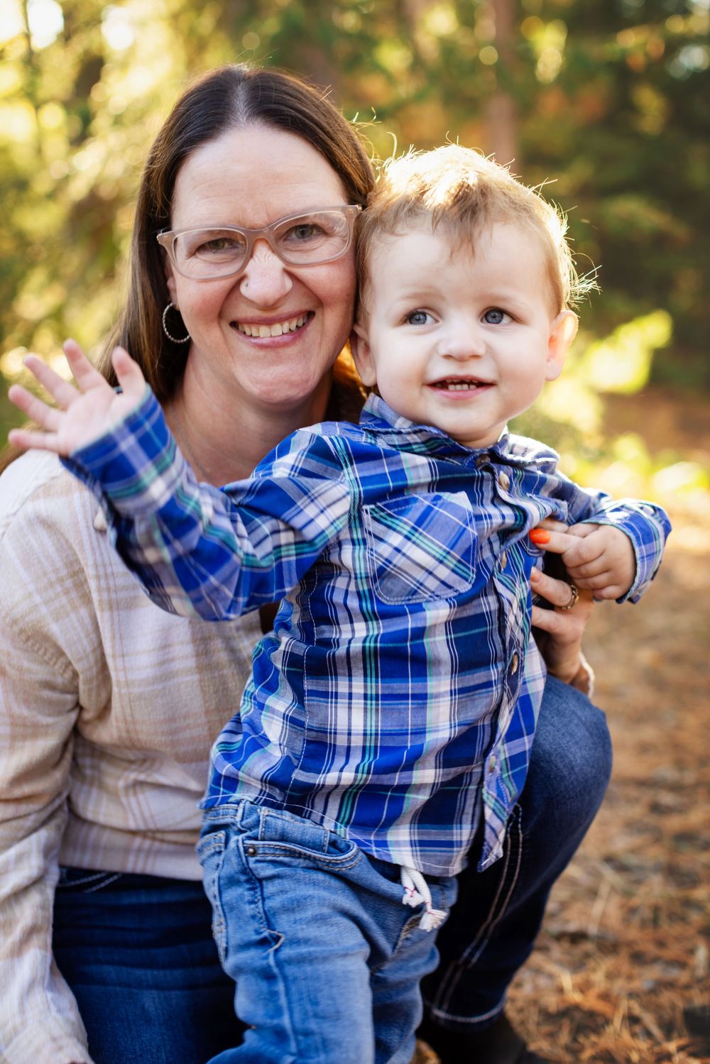 A happy pair wearing coordinating blue plaid shirts share a joyful moment together outdoors on an autumn day.