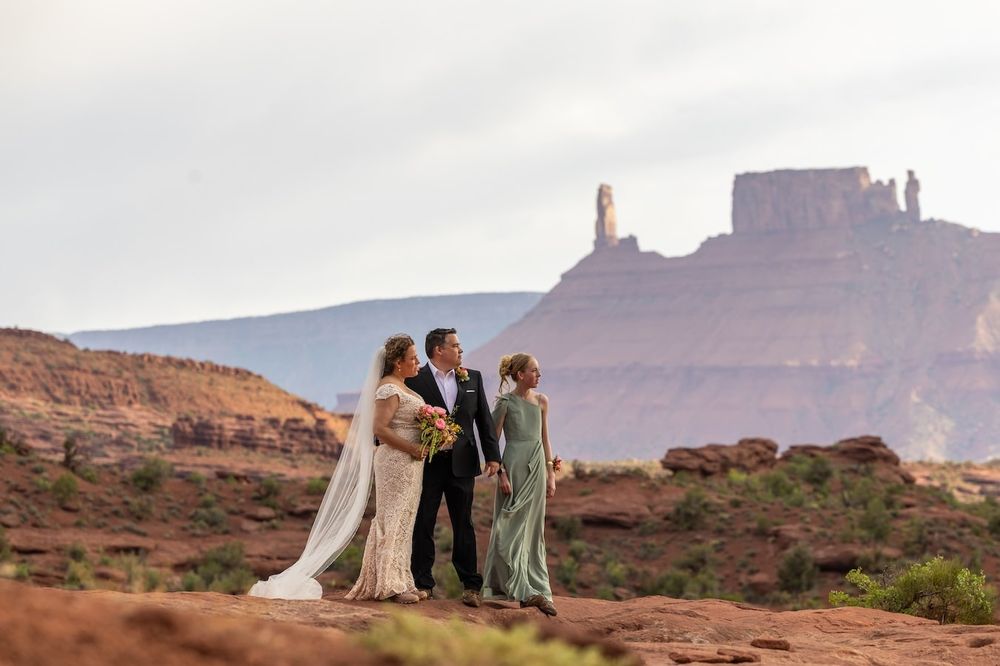 couple in a desert landscape posing for photos at castle valley