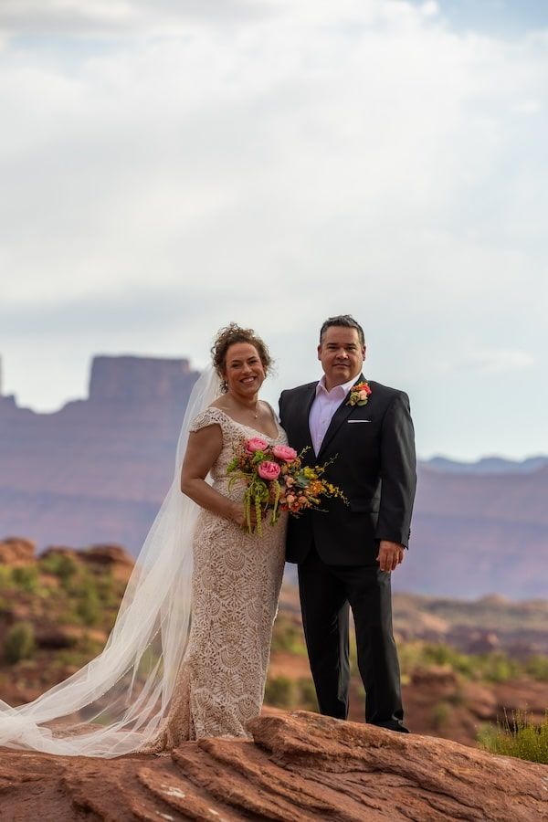 couple in a desert landscape posing for photos at castle valley