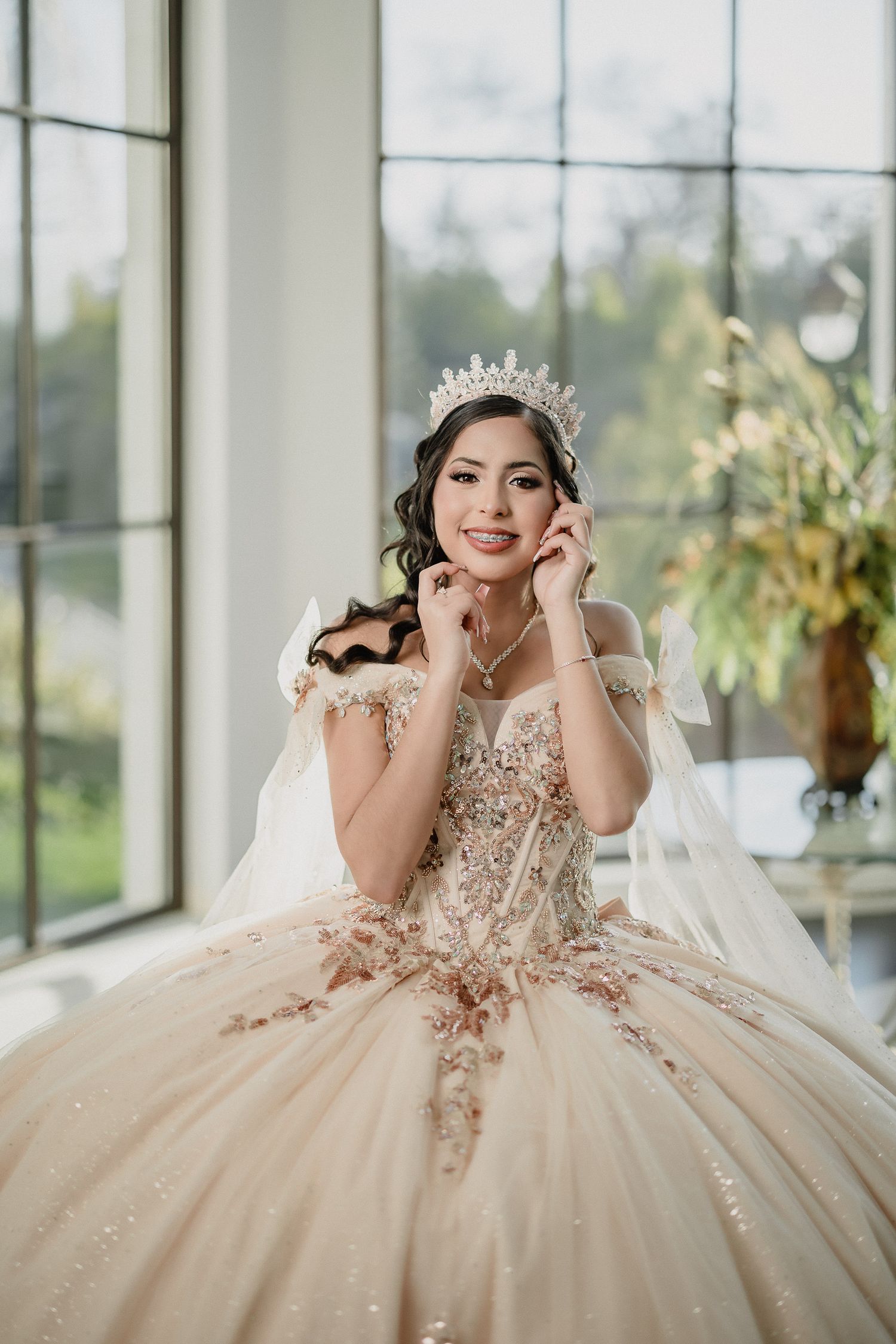 A regal ballgown with crystal embellishments and tiara photographed by bright windows.