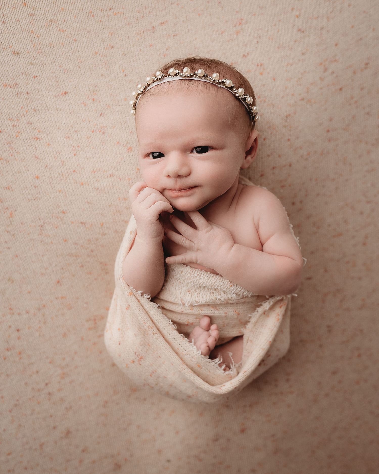 Professional photo of a newborn baby awake and looking at the camera