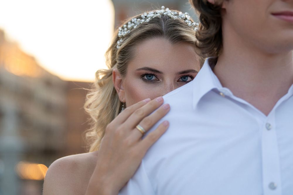 A close-up shot of a bride wearing a delicate crystal tiara during sunset with her partner in a white shirt.