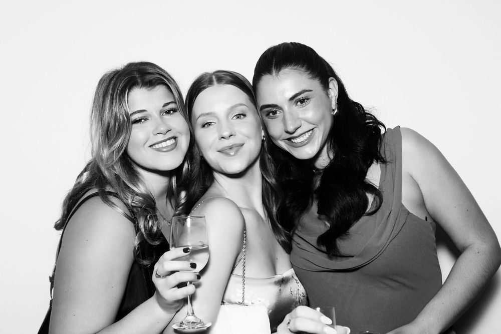 Three women pose for Black and White GLAM Booth photo.