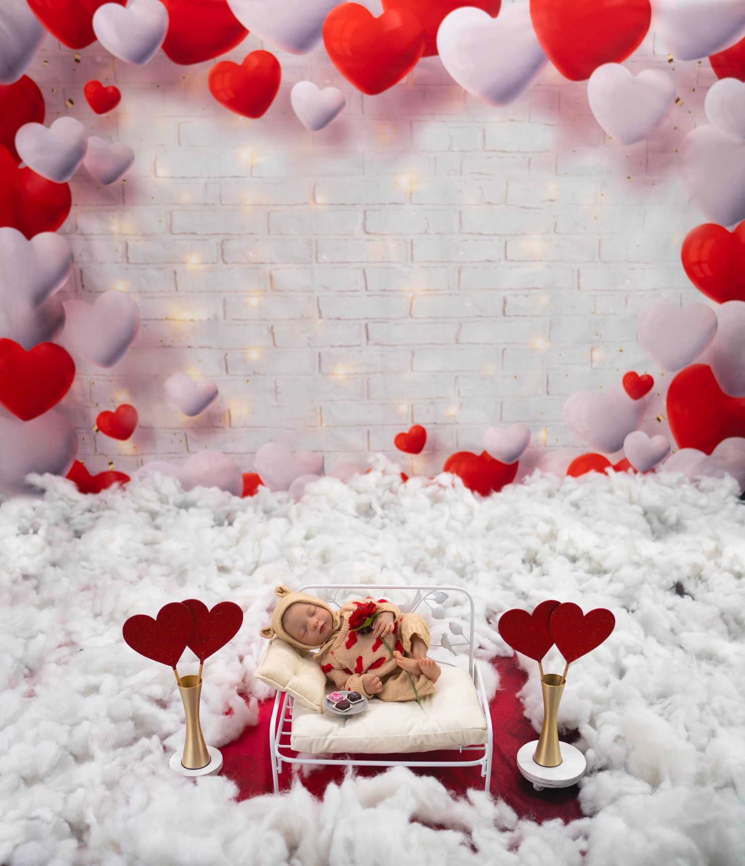 Valentine's day photo backdrop with red and white heart balloons against white brick wall.