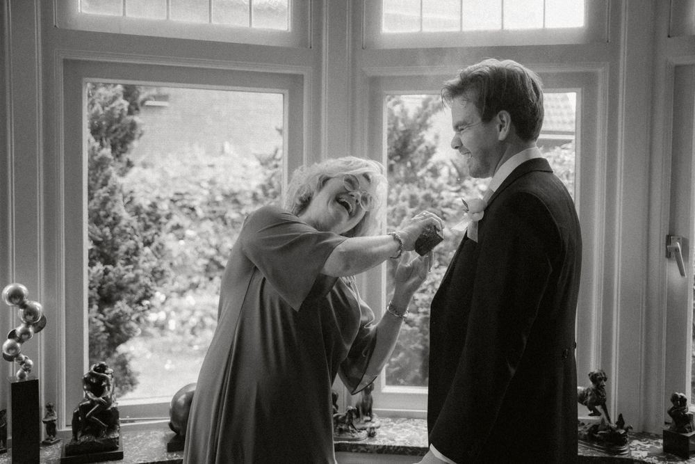 A vintage black and white photograph showing two people having an intimate conversation by a bright window.
