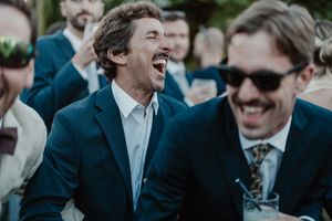 Unfiltered moment of two guests in a deep hug, drink in hand — cinematic cocktail storytelling at The Astoria