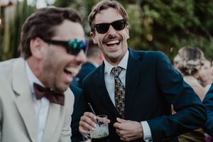 Unfiltered moment of two guests in a deep hug, drink in hand — cinematic cocktail storytelling at The Astoria