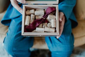 Wedding rings and keepsakes presented in a red velvet box — flatlay detail captured at The Astoria.