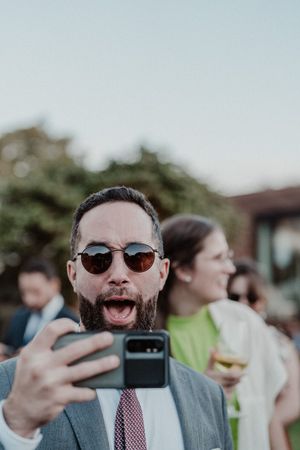 Guest dancing with a drink in hand before dinner — cocktail chaos at The Astoria wedding party